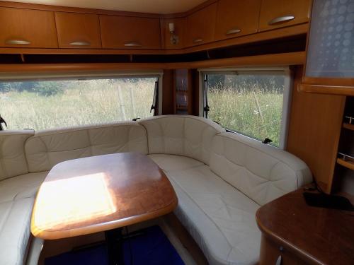 a living room with a white couch and a table at Caravan du Loch in Gaël