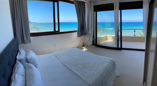 a bedroom with a bed with a view of the ocean at Villa Sunset Siviri in Siviri