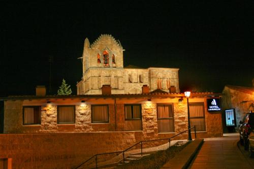 a building with a clock tower on top of it at night at Hotel Las Murallas in Avila