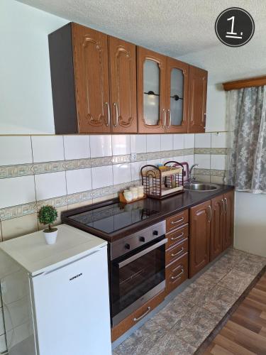 a kitchen with wooden cabinets and a stove top oven at Apartments Sokolović in Višegrad