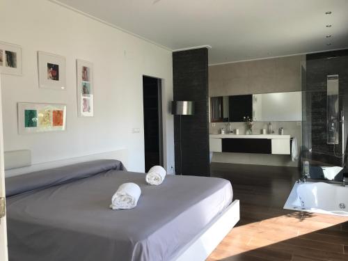 a bedroom with a bed and a bathroom with a tub at Villa Xauxa - Vida mediterránea in Gandía