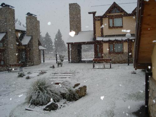a house covered in snow in a yard at Ayelen Andina in Esquel