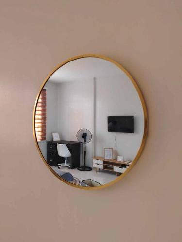 a mirror hanging on a wall with a living room at La Mirie Calumpit 2 in Balite