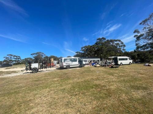 a group of vehicles parked in a grass field at Humbug Views - Bunk House & Hot Tub! in St Helens