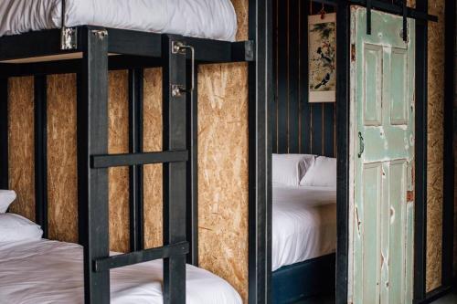 a couple of bunk beds in a room with a door at Humbug Views - Bunk House & Hot Tub! in St Helens
