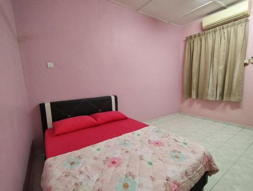a bedroom with a bed with a red pillow at Malim Joyous Homestay - rent room only in Melaka