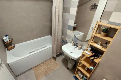 a bathroom with a tub and a toilet and a sink at Urban Escape Apartment in Pobrežje