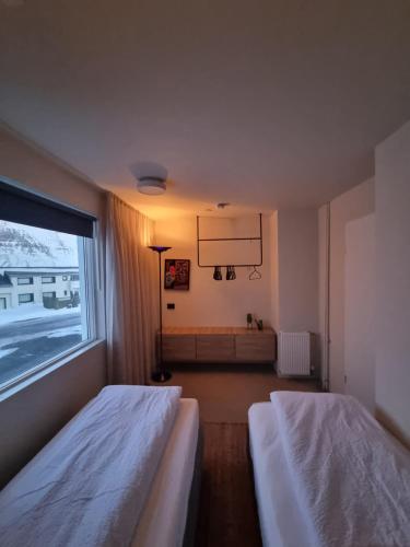 BolungarvíkにあるDúfan Apartmentsのベッドが2つと大きな窓がある寝室