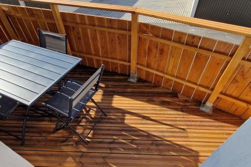 une terrasse en bois avec une table et des chaises dessus dans l'établissement Le Petit Colin RDC, à Pontarlier