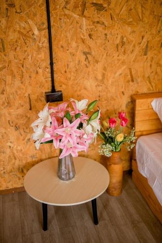 a vase of flowers on a table in a bedroom at KheangKhangKhao เคียงข้างเขา ปัว-สกาด in Pua