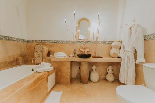 a bathroom with a tub and a sink and a toilet at Dar El Qadi in Marrakech