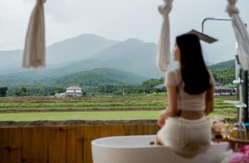 a woman sitting in a bath tub with a view at KheangKhangKhao เคียงข้างเขา ปัว-สกาด in Pua
