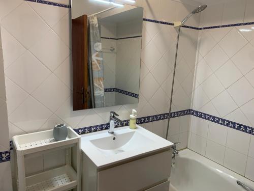 a bathroom with a sink and a mirror and a tub at Sesimbra Concept in Sesimbra
