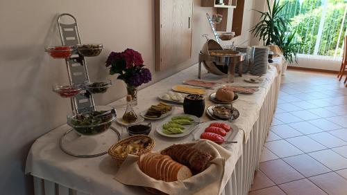 une longue table blanche avec de la nourriture dans l'établissement Willa Global komfortowe pokoje nad morzem, à Jastrzębia Góra