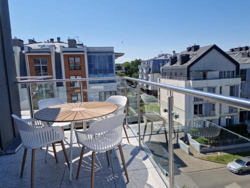 a patio with a table and chairs on a balcony at Apartamenty na Wyspie - Stella Baltic - Parking in Świnoujście