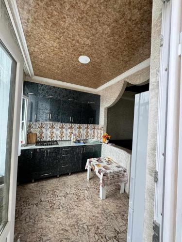 a kitchen with black cabinets and a bench in it at Apartment for rent daily ქირავდება ბინა დღიურად in Mejinistsqali