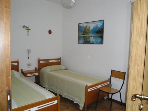 een kamer met twee bedden en een kruis aan de muur bij Casa Valentina ANIMALI NON AMMESSI in Montesilvano