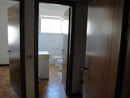 een badkamer met een toilet en een raam en een deur bij Casa Valentina ANIMALI NON AMMESSI in Montesilvano