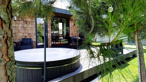 a patio with a table and chairs and trees at airzeb Uno - A3 Highway at Borș2 in Biharia
