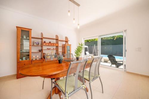 a dining room with a wooden table and chairs at Casa Férias Charneca da Caparica in Charneca