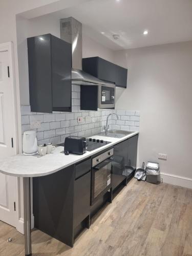 a kitchen with black cabinets and a counter top at The Sherwood Guest House in Eastbourne