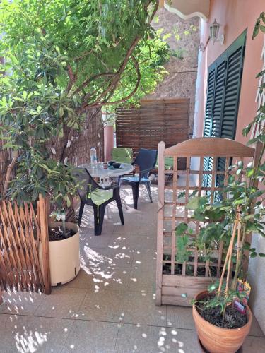 a patio with a table and chairs and trees at Le Clos Osteria in Barbaggio