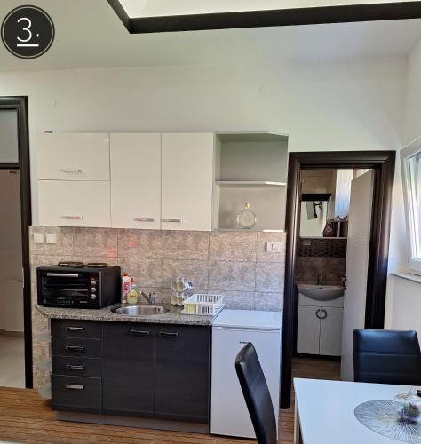 a kitchen with a sink and a microwave at Apartments Sokolović in Višegrad