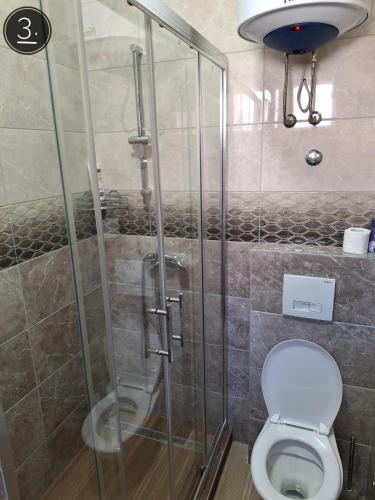a shower stall in a bathroom with a toilet at Apartments Sokolović in Višegrad