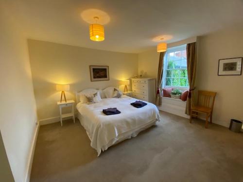 a bedroom with a white bed and a window at Stunning 3 bedroom 3 bath self catering cottage nr Stonehenge, Longleat, Avebury and Bath in Pewsey