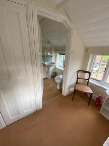 a hallway with a toilet and a chair in a room at Stunning 3 bedroom 3 bath self catering cottage nr Stonehenge, Longleat, Avebury and Bath in Pewsey