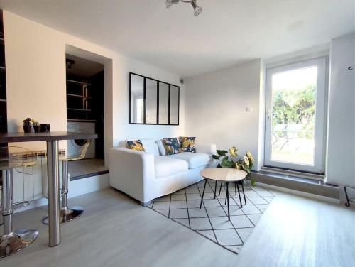 un salon avec un canapé blanc et une table dans l'établissement Émeraude proche hippodrome, à Aix-les-Bains