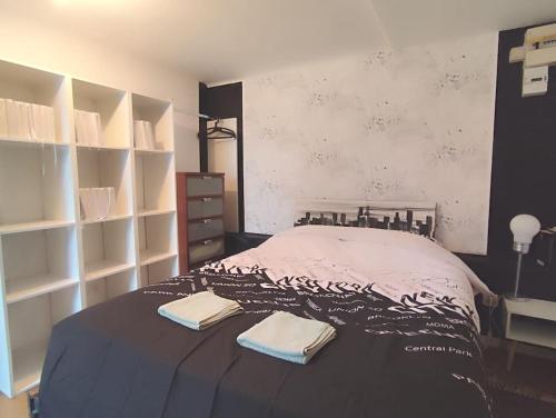 une chambre avec un lit avec deux serviettes dessus dans l'établissement Émeraude proche hippodrome, à Aix-les-Bains