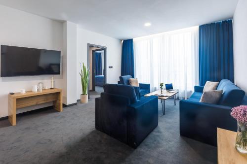 a living room with blue furniture and a flat screen tv at Blue Star Luxury Hotel in Sofia