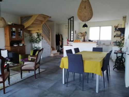 une cuisine et une salle à manger avec une table et des chaises jaunes dans l'établissement Maison de ville avec jardin en lisière de campagne, à Guérande