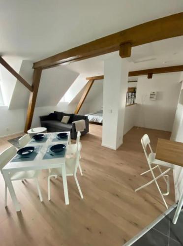 un salon avec une table et des chaises blanches dans l'établissement Studio cosy comme à la maison, à Mulhouse