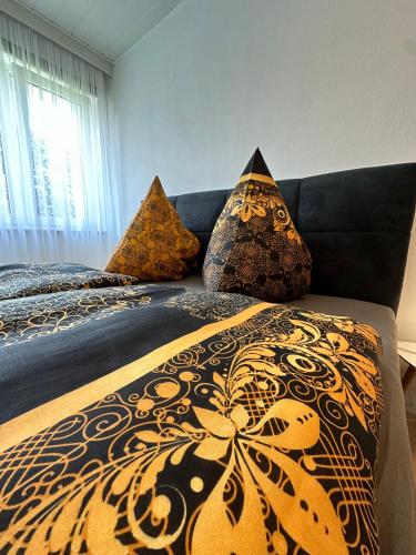 a bedroom with two beds with a black and gold blanket at Gemütliches Appartement - WBS in Goldkronach
