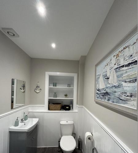 a bathroom with a white toilet and a sink at Class Apartments in Peterhead