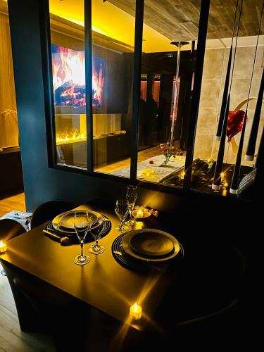 - une table avec des verres à vin et des lumières dans l'établissement Les Secrets Rooms - Bonneval - Love Room - Spa et Hammam Privatif, à Bonneval