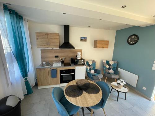 une cuisine et une salle à manger avec une table et des chaises dans l'établissement Les Hirondelles A, au Crotoy