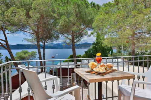 a table and chairs on a balcony with a view of the water at Camping Village Le Calanchiole in Capoliveri