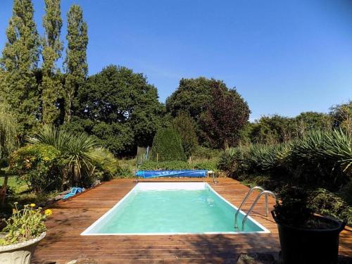 une piscine au milieu d'un jardin dans l'établissement Caravan du Loch, à Gaël