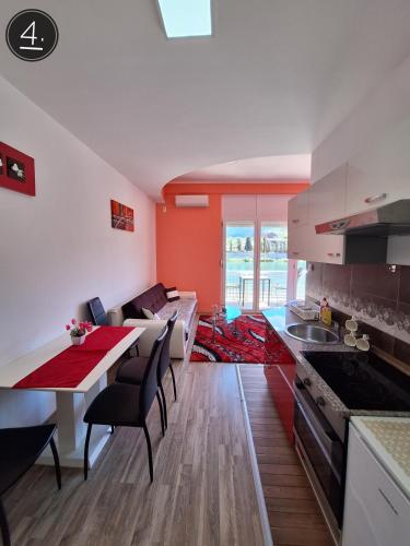 a kitchen and living room with a table and a couch at Apartments Sokolović in Višegrad