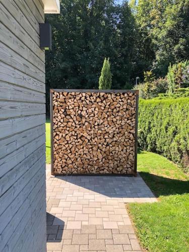 a pile of fire wood sitting next to a fence at Schönes Haus mit Pool & Garten in Hagenbuch
