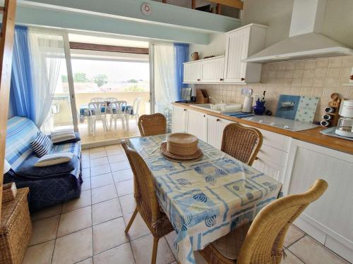une cuisine avec une table, des chaises et une table. dans l'établissement Charmant appartement rénové avec loggia et parking, proche de la mer à Marseillan - FR-1-387-144, à Marseillan
