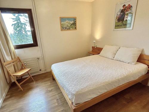 une chambre avec un lit, une chaise et une fenêtre dans l'établissement Appart 2 pièces + mezzanine, 6 couchages, Megève, parking - FR-1-597-7, à Megève