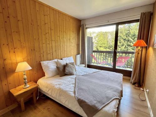 une chambre avec un lit et une grande fenêtre dans l'établissement Appartement cosy 2 pièces avec balcon, proche centre et télécabine, piscine et tennis en été - FR-1-597-20, à Megève