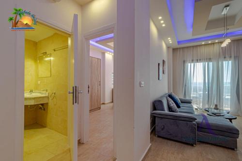 een woonkamer met een bank en een badkamer bij Turtles Beach Resort Hurghada By VTGooo in Hurghada