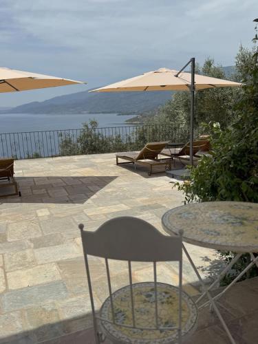 a patio with a table and chairs and umbrellas at Villa Wishflower in Lefokastro