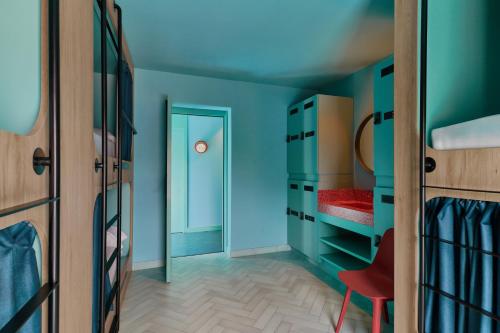 a room with blue walls and a red chair at The Boc Hostels - Beach in Can Pastilla
