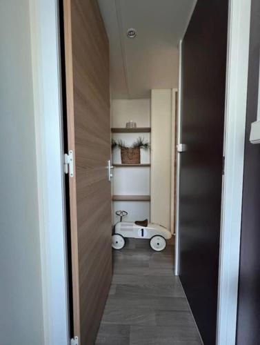 un couloir avec une porte menant à une chambre équipée d'une voiture à jouets dans l'établissement Charmant Mobile Home Cap-Ferret, à Lège-Cap-Ferret
